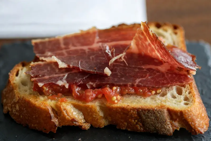 Tostada de pan rústico con tomate rallado y jamón ibérico